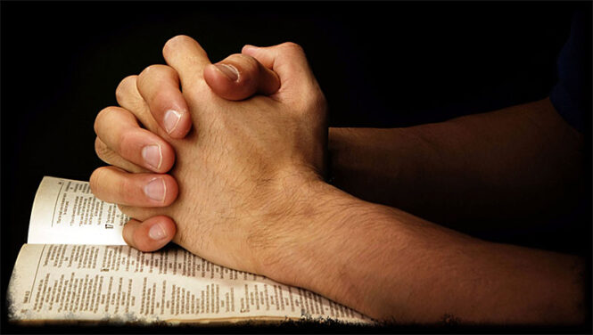 praying hands on Bible