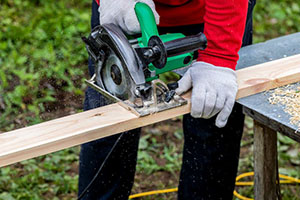 photo of someone cutting a board with an portable electric saw